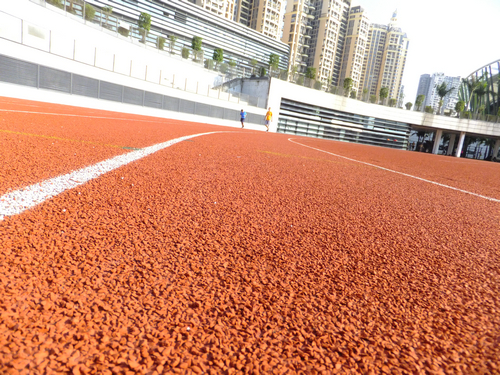 实拍深圳宝安体育馆足球场景观，有工人在维护有市民在跑步