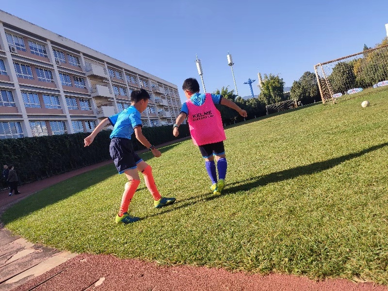 开学上学校踢球,春天到了小朋友们在草地上踢足球