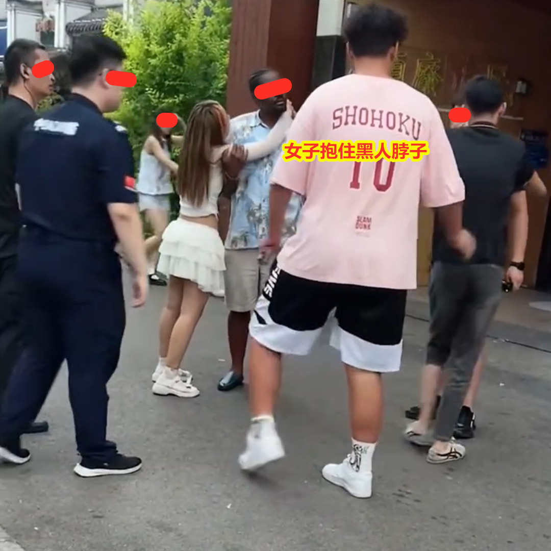 女子移情黑人男子，男友上前想将二人分开，女子哭着抱紧不肯松手